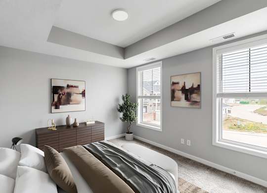 A bedroom with a large bed and a window with blinds.