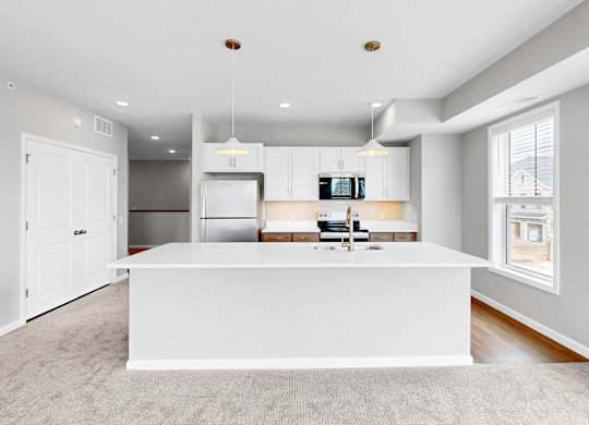 A modern kitchen with a white island in the middle.