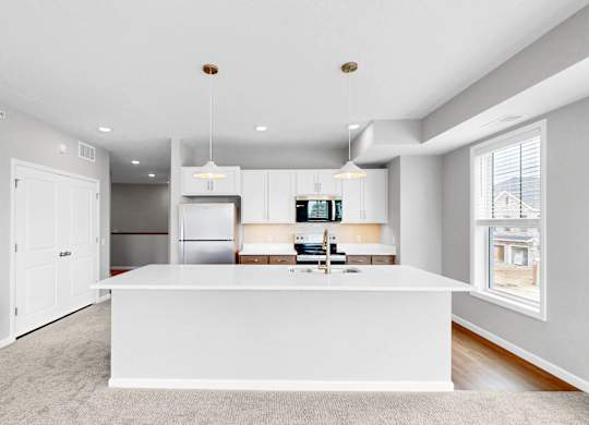 A modern kitchen with white cabinets and a large island.
