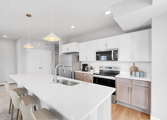 A modern kitchen with a white countertop and white cabinets.