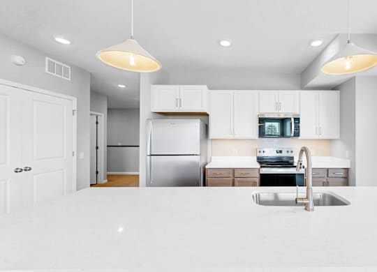 A modern kitchen with white cabinets and appliances.