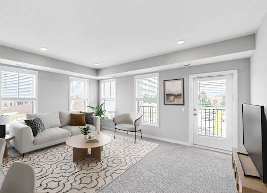 A living room with a white couch, a coffee table, and a television.