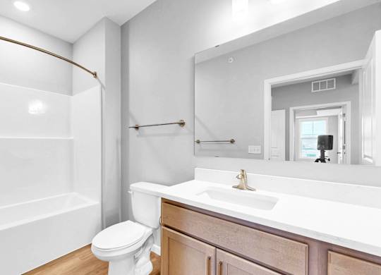 A white bathroom with a toilet, sink, and bathtub.