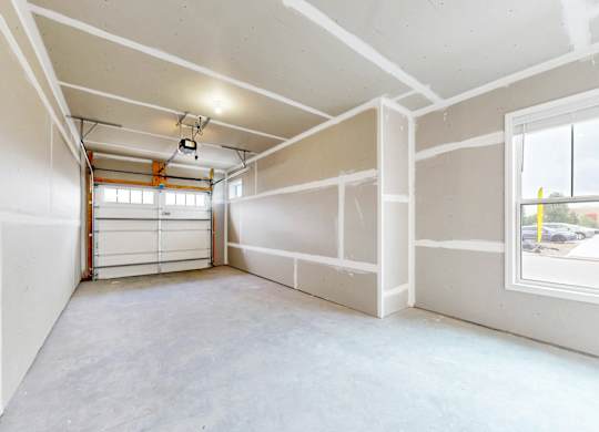 A room with white walls and a concrete floor is shown.