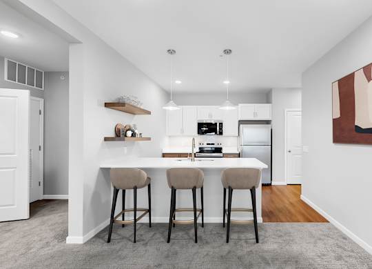 A kitchen with a bar stool and a painting on the wall.