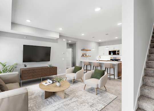 A modern living room with a large flat screen TV, a sofa, a coffee table, and a staircase.
