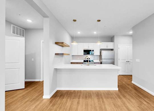 A kitchen with white cabinets and a wooden island.