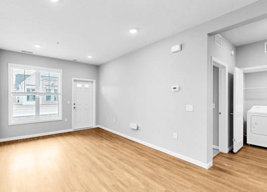 A room with a window, a door, and a wall socket.