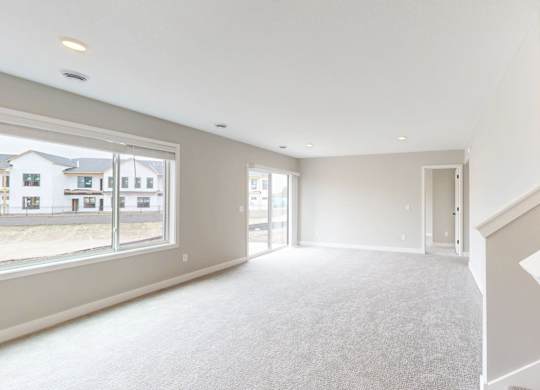 Spacious living room with carpeting and staircase at Wildwood Lakeville Apartments, Lakeville, MN 55044