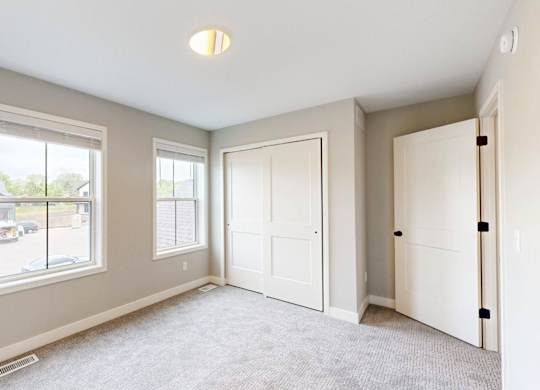 Carpeted bedroom with closet and alcove at Wildwood Lakeville Apartments, Lakeville, MN 55044