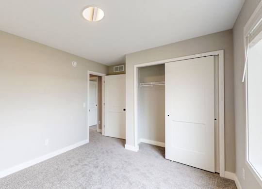 Spacious bedroom with walk-in closet and carpet at Wildwood Lakeville Apartments, Minnesota