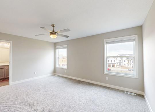 Master bedroom with ceiling fan and ensuite bathroom at Wildwood Lakeville Apartments, Minnesota, 55044