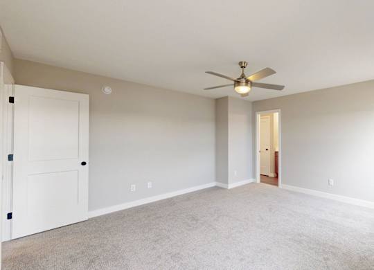 Spacious bedroom with neutral walls and carpet at Wildwood Lakeville Apartments, Minnesota