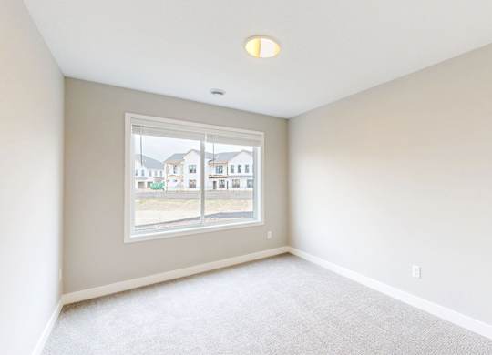 Empty carpeted room with window overlooking community at Wildwood Lakeville Apartments, Lakeville, MN 55044