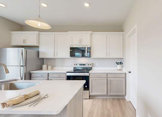 Bright kitchen with stainless appliances and white cabinetry at Wildwood Lakeville Apartments, Lakeville, MN