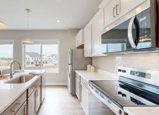 Galley kitchen with stainless steel appliances and white countertops at Wildwood Lakeville Apartments, Lakeville, 55044