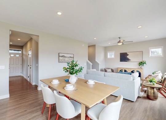 Dining area with wood table and gray sofa at Wildwood Lakeville Apartments, Lakeville