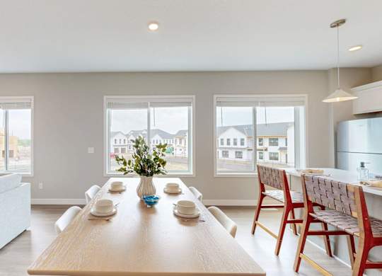 Dining room with wood table and woven accent chairs at Wildwood Lakeville Apartments, Lakeville, MN