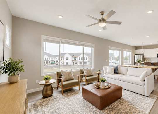 Spacious living room with modern furnishings and ceiling fan at Wildwood Lakeville Apartments, Lakeville, MN