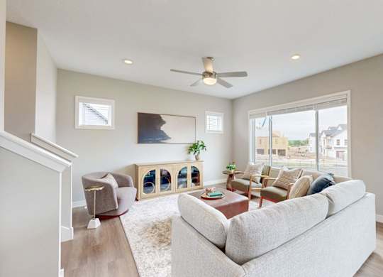 Living room with neutral tones and large window at Wildwood Lakeville Apartments, Lakeville