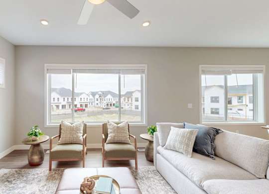 Contemporary living room with armchairs and modern decor at Wildwood Lakeville Apartments, Lakeville