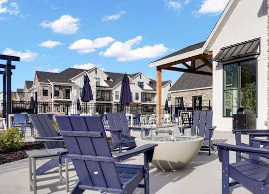 A sunny day at a poolside with blue chairs and a hot tub.