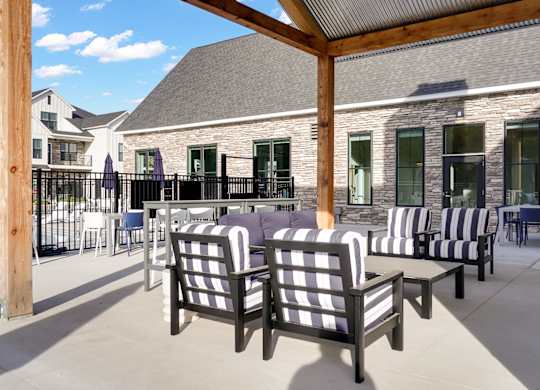 A patio with black and white striped chairs and a wooden pole.