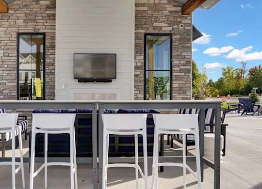 A patio with a table and chairs is set up outside a house.