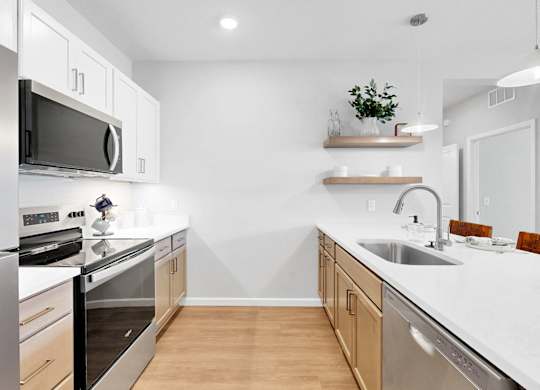 A modern kitchen with stainless steel appliances and wooden cabinets.