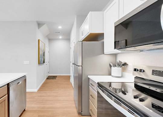 A modern kitchen with stainless steel appliances and wooden cabinets.