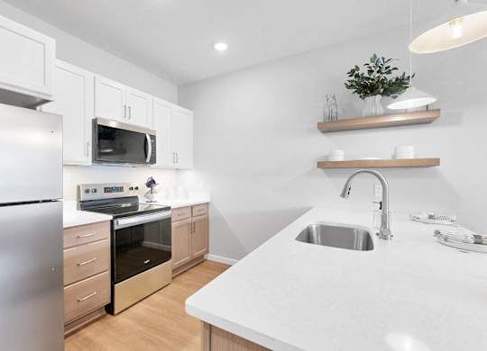 A modern kitchen with a stainless steel refrigerator and a white countertop.