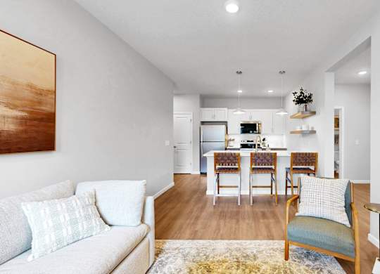 A living room with a couch, chairs, and a dining table.