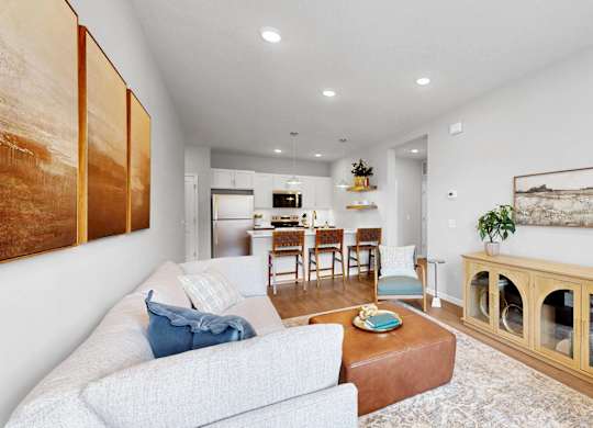 A living room with a grey couch and a wooden cabinet.