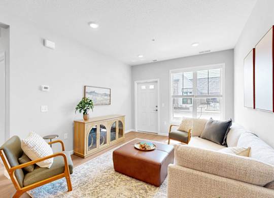 A living room with a chair, couch, and a table.