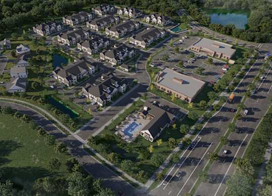 Aerial view of residential community with parking and pond at Wildwood Lakeville Apartments, Lakeville, MN
