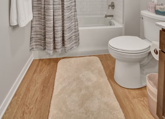 a bathroom with a white toilet next to a bathtub with a shower curtain