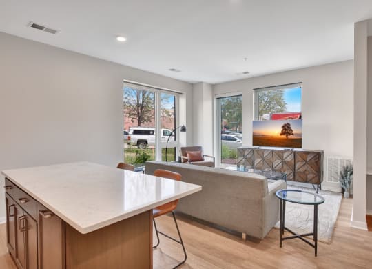 a kitchen with an island and a living room with a couch and a coffee table
