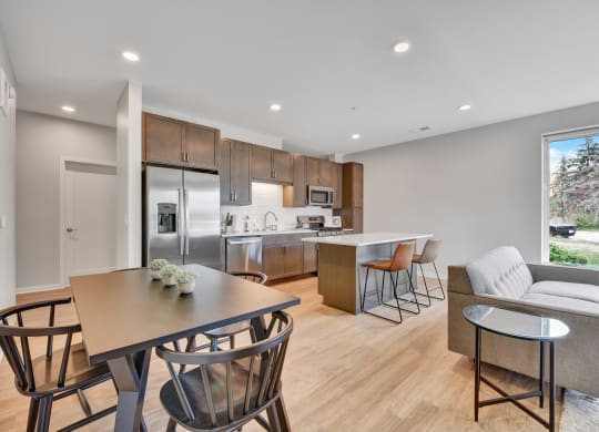 a kitchen and living room with wood flooring and a large window