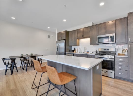 a kitchen with a large center island with a white quartz top
