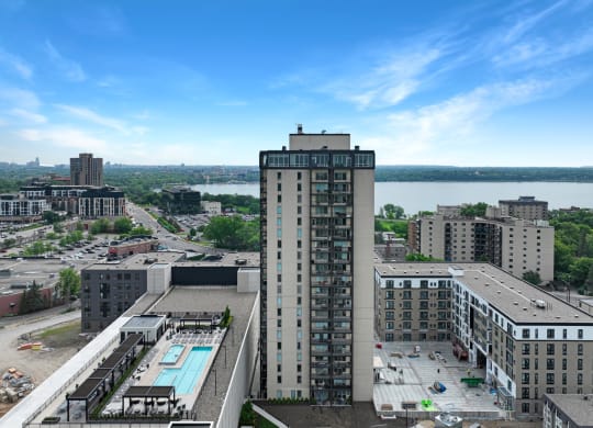 an aerial view of a tall building with a pool in front of it