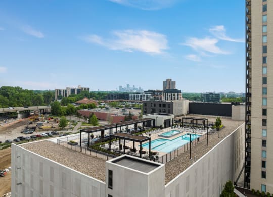 a view of the pool from the top of a building with a city in the background