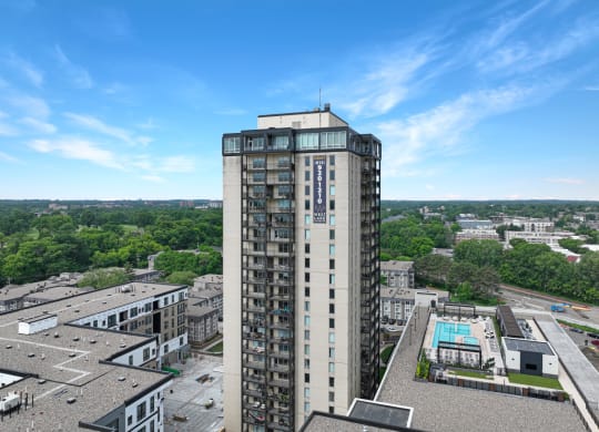 an aerial view of a tall building with a pool in front of it