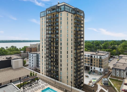 an aerial view of a tall building with a pool in front of it