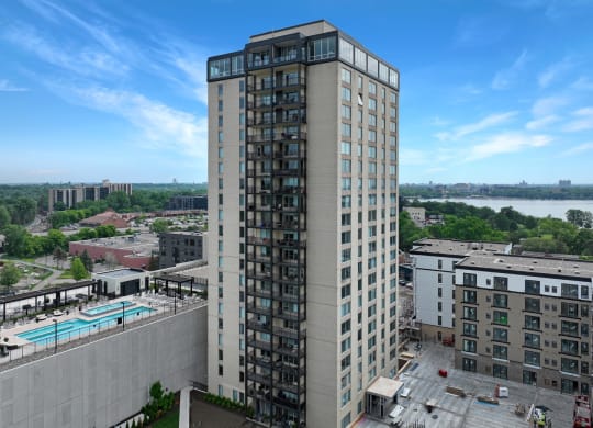 an aerial view of a tall building with a pool in front of it