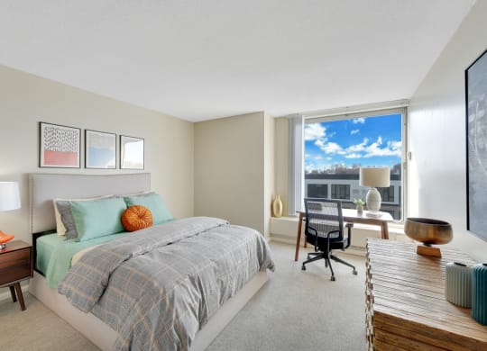 a bedroom with a bed and a desk with a window