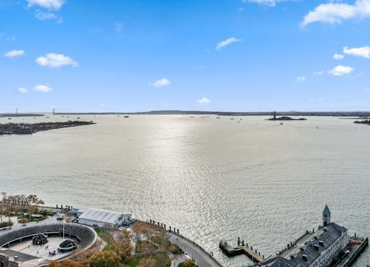 A large body of water with a building and a pier in the distance at One West, New York.