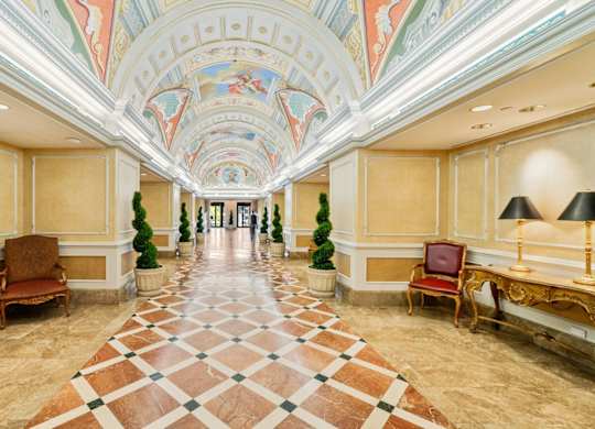 A long hallway with a checkered floor and chairs on either side at One West,New York, NY.