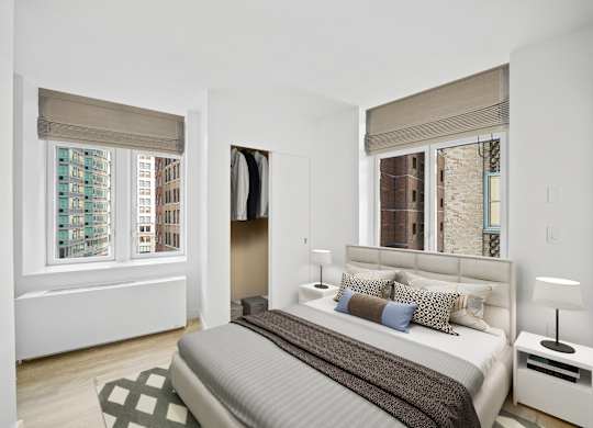 A bedroom with a large bed and a window with a view of a city at Aria, New York