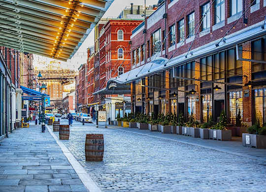 A cobblestone street with wooden barrels lined up on the side at Aria, New York