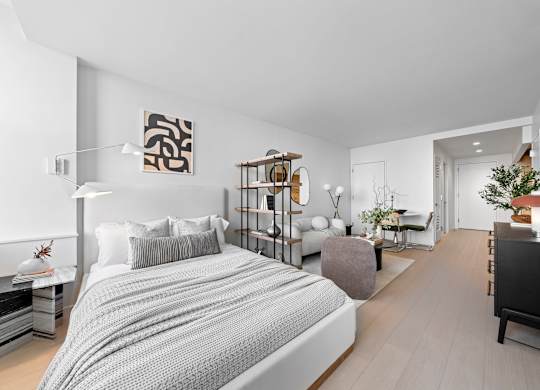 A modern bedroom with a large bed and a wooden floor at One West, New York